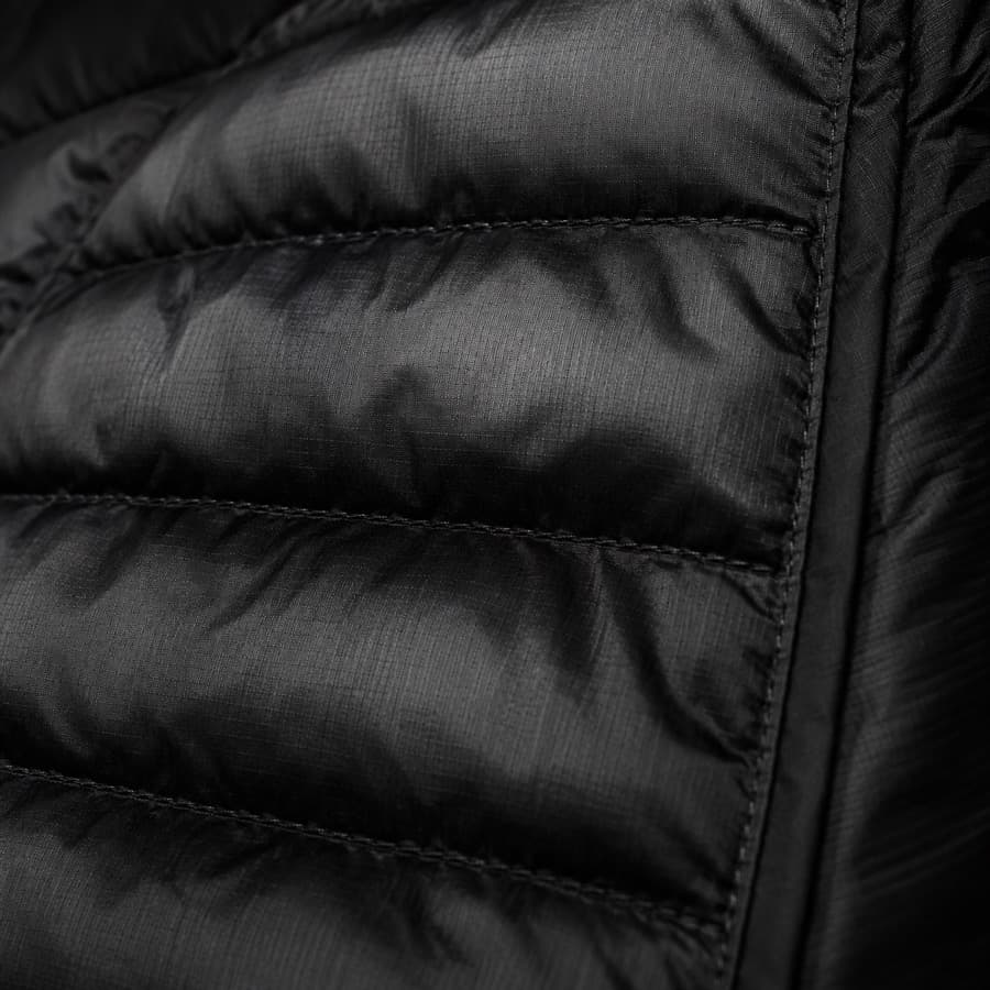 Macro photograph of a black quilted down jacket panel.